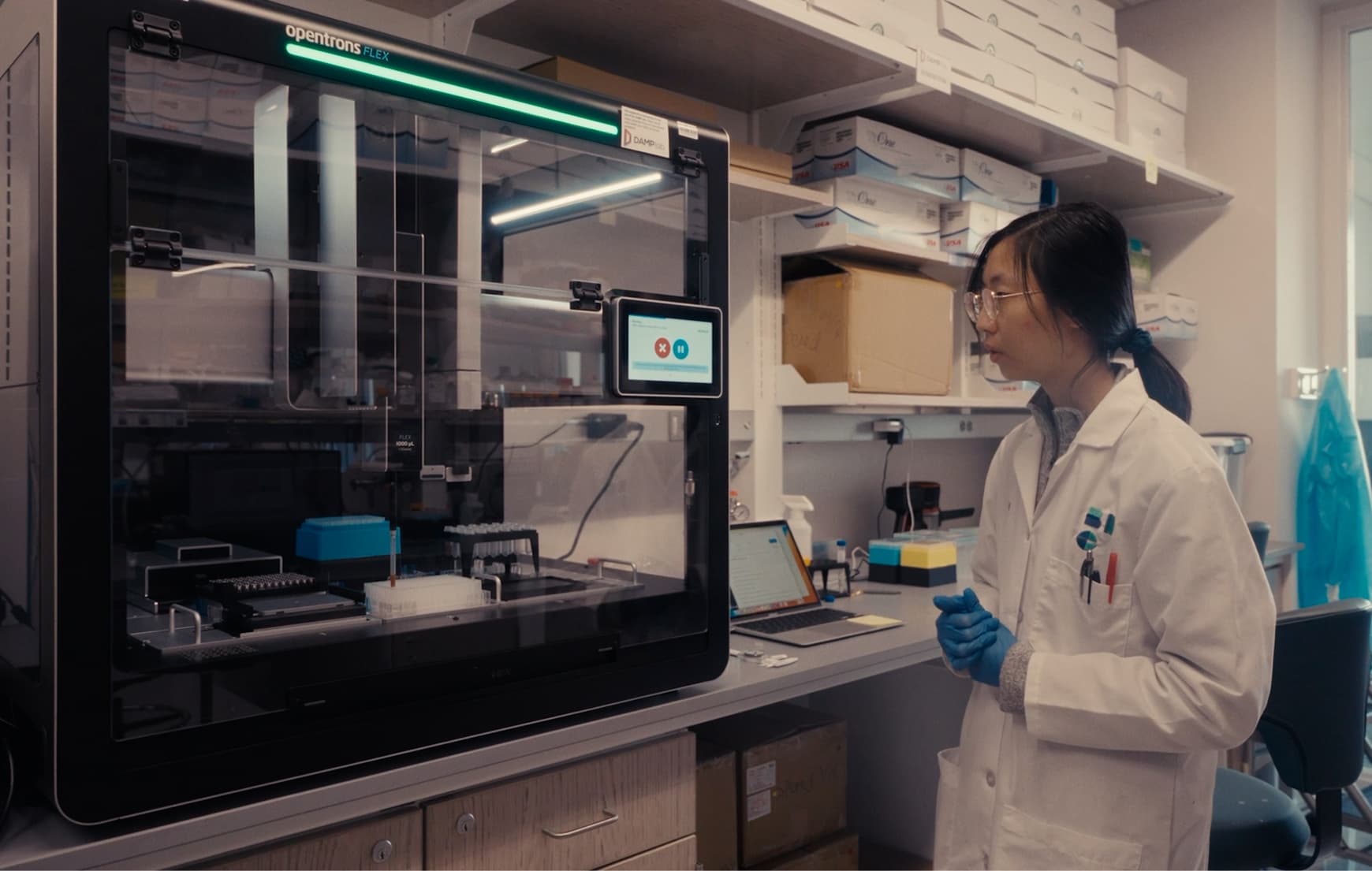 Scientist looking at an Opentrons Flex sitting on a lab bench